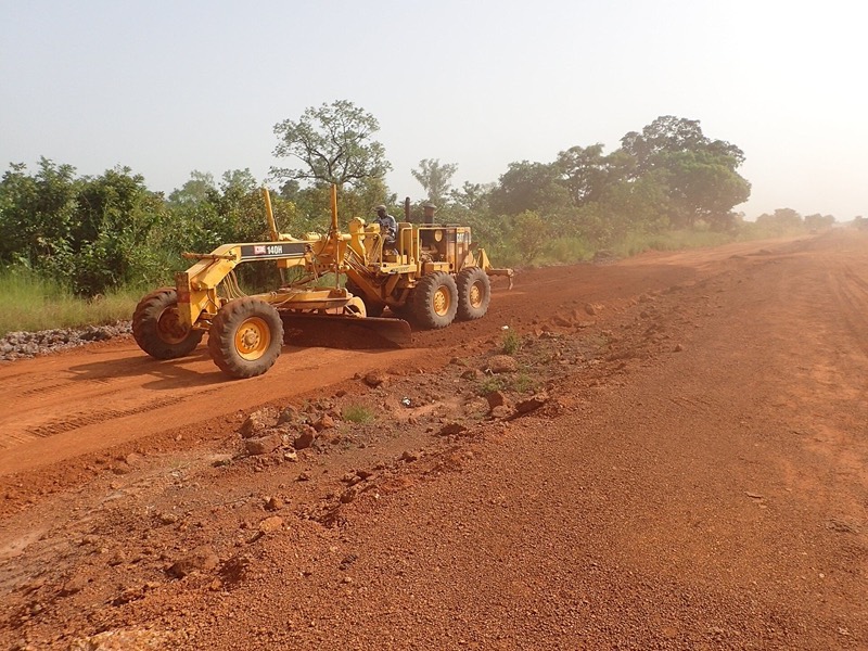 Niveleuse sur une piste en latérite rouge, Sénégal